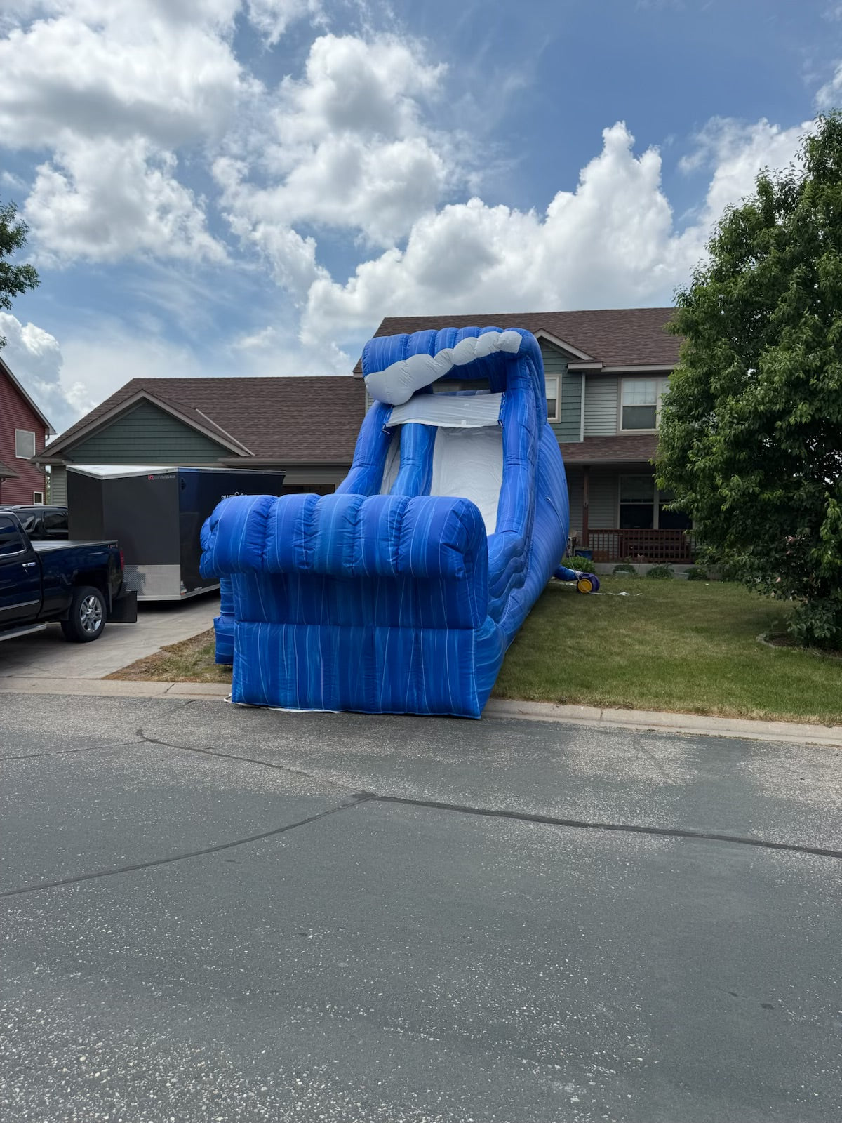 Inflatable slide on a driveway with a house and trees in the background