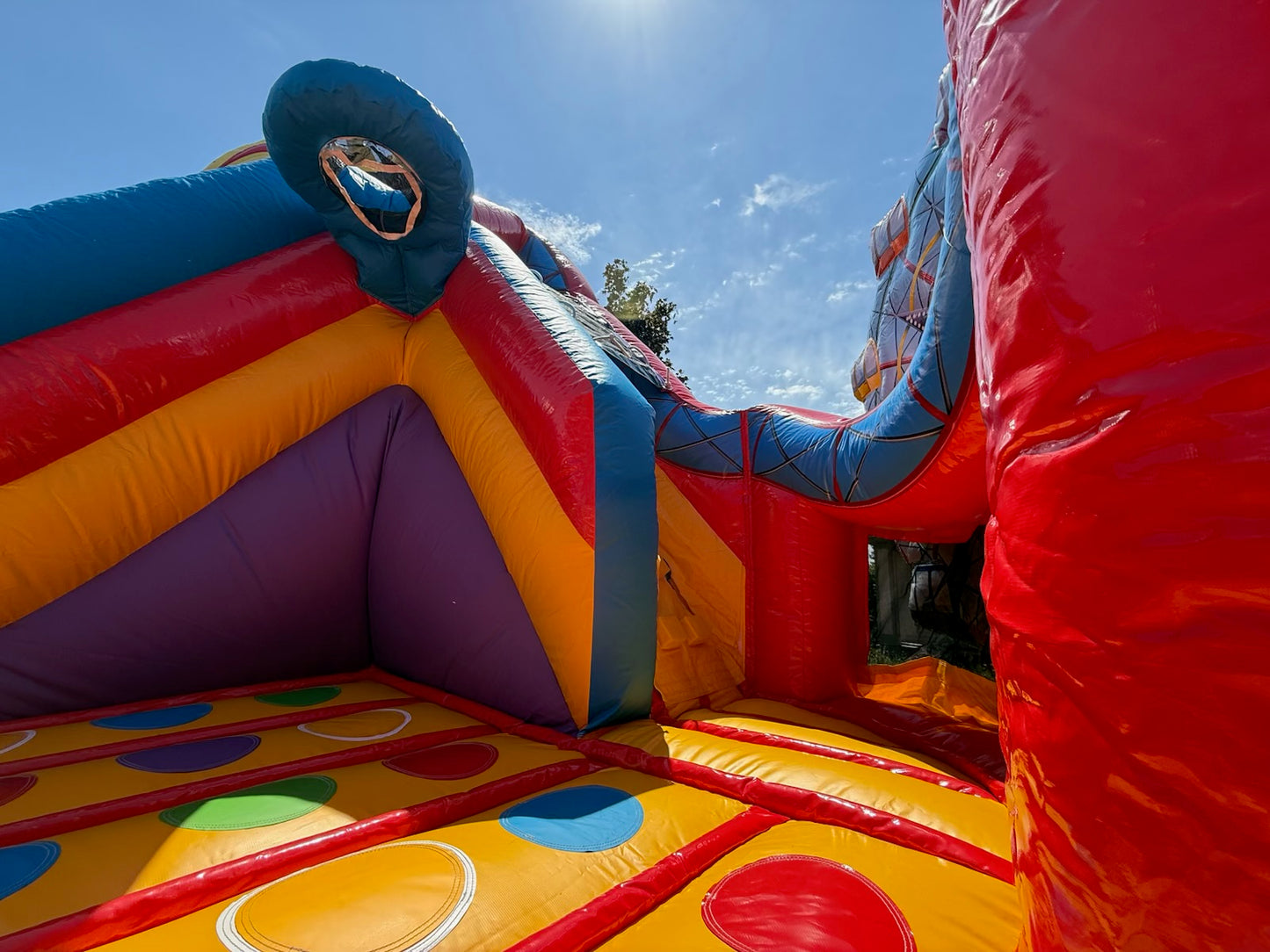 Colorful inflatable bounce house with a clear blue sky background