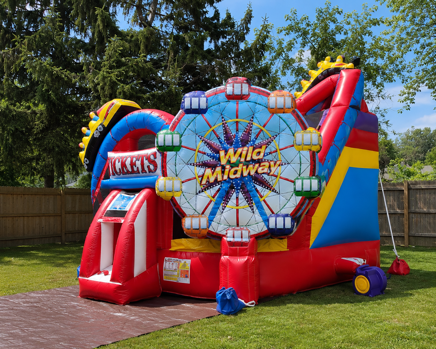 Colorful inflatable amusement park with Ferris wheel design on a grassy area.