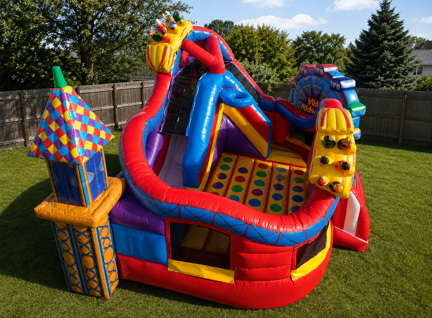 Colorful inflatable playground structure on grass with trees in the background