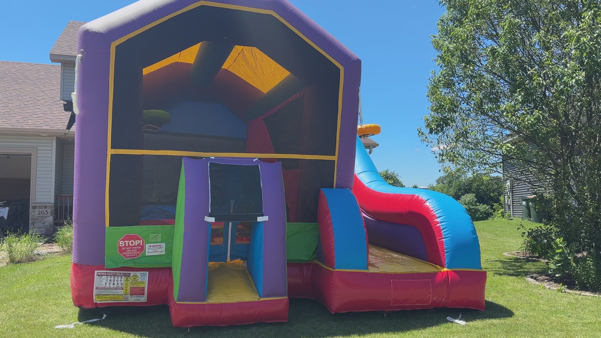 Video walkthrough of a colorful bounce house with vibrant slide, climbing wall, and spacious play area, perfect for kids' parties and events.